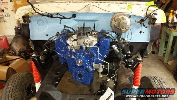 Blue engine installed in vehicle frame with red shock absorbers
