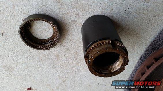 Wheel bearing lock nut and socket on concrete. The socket has teeth around the opening