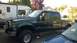 2007 Ford F-250 - A dark green 2007 Ford F-250 Super Duty crew cab pickup truck is parked in a driveway.