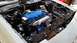 1985 Ford Escort - Engine bay of a white car, showing the engine with a blue valve cover and silver intake manifold.
