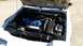 1985 Ford Escort - The engine bay of a white car is shown with the hood open. The engine has blue valve covers.