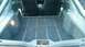 1985 Ford Escort - The rear cargo area of a car is shown, carpeted floor and side panels.