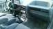 1985 Ford Escort - The interior features a manual transmission shifter and three aftermarket gauges mounted below the center console.