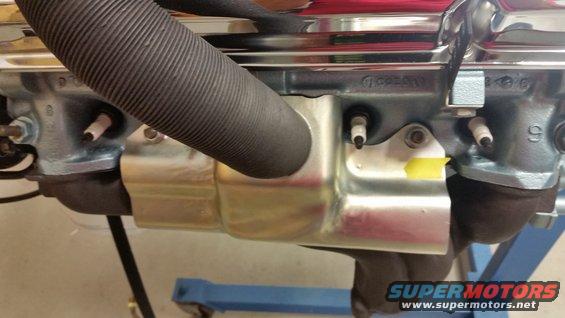 Close-up of engine block with spark plug wires and exhaust manifold