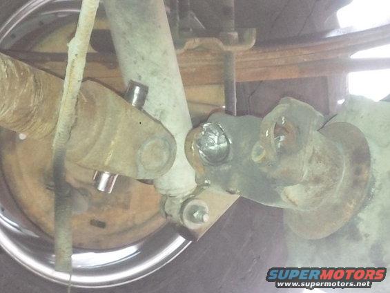 Driveshaft U-joint and suspension parts, rusty metal, chrome rim