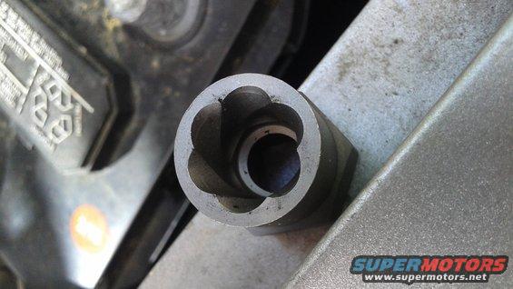 Close-up of a star-shaped socket for a lug nut, near a car battery