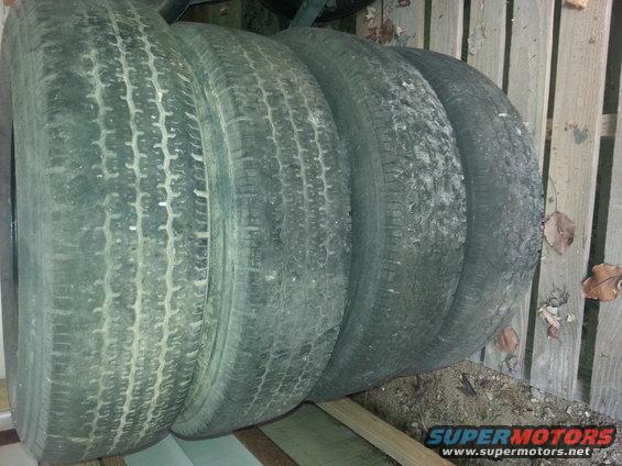 Four stacked tires, some with visible tread wear