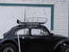 1964 Volkswagen Beetle - Side view of a black 1964 Volkswagen Beetle equipped with a roof rack and modified tires.