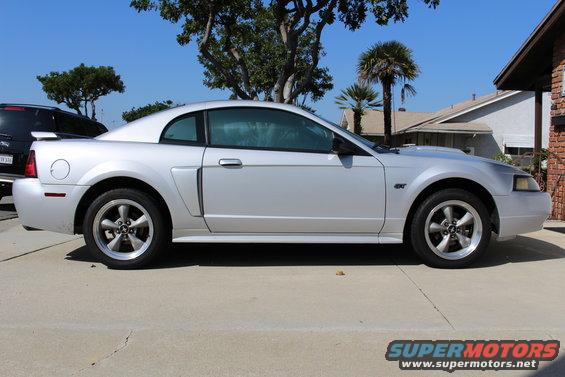 Silver 2002 Ford Mustang GT coupe parked on concrete, side view