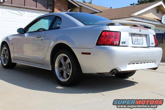 Silver 2002 Ford Mustang GT parked in driveway, rear 3/4 view