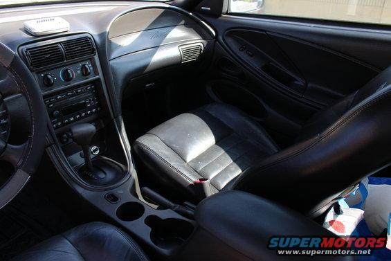 Interior shot of a 2002 Ford Mustang, showing dashboard, seats, and center console