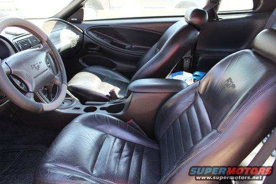 Black leather interior of a 2002 Ford Mustang, showing seats and steering wheel