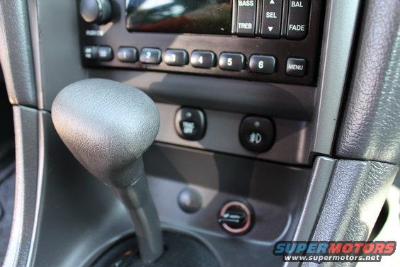2002 Ford Mustang interior showing automatic gear shifter, radio buttons, and climate controls