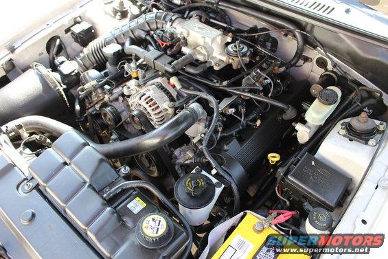 2002 Ford Mustang engine bay with V8 engine, battery, and coolant reservoir visible