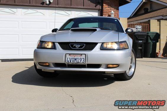 Silver 2002 Ford Mustang front view with California license plate 4VQM193 parked in front of a garage