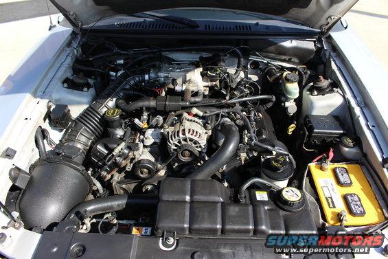 2002 Ford Mustang engine bay with V8 engine, air intake, battery, and fuse box visible