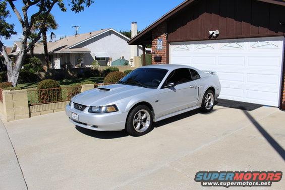 Silver 2002 Ford Mustang parked in front of a garage