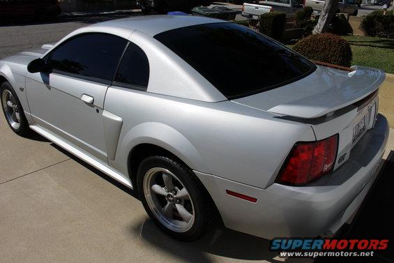 Silver 2002 Ford Mustang coupe, rear quarter view. Tinted windows, aftermarket spoiler