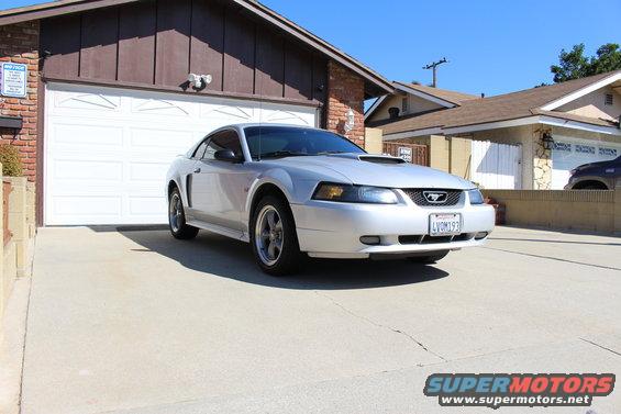 Silver 2002 Ford Mustang coupe with hood scoop parked in driveway