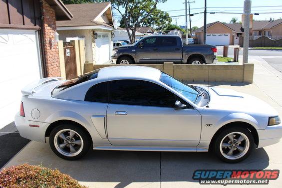 Silver coupe parked in driveway, gray pickup truck behind it
