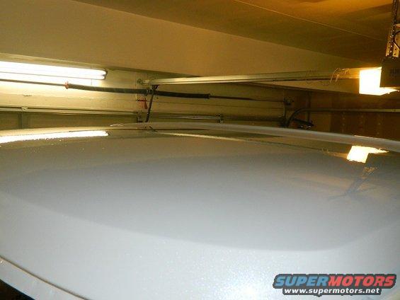 White vehicle roof in a garage with overhead door mechanism visible