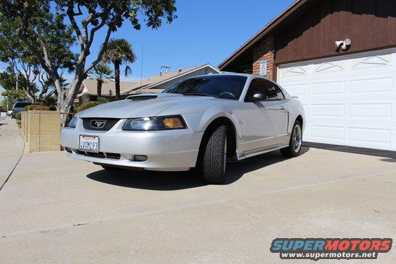Silver 2002 Ford Mustang parked in front of a garage, front quarter view