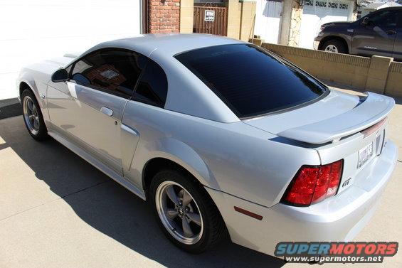 Silver 2002 Ford Mustang parked outside a garage