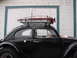 1964 Volkswagen Beetle - A black 1964 Volkswagen Beetle is equipped with a roof rack holding a red Hi-Lift jack.