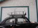 1964 Volkswagen Beetle - A vintage Volkswagen Beetle is parked outside a garage, fitted with a large metal roof rack.