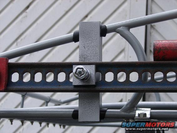 Close-up of a metal bracket with a star-shaped bolt head and perforated metal strip