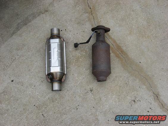 New shiny catalytic converter next to an old rusty one on concrete