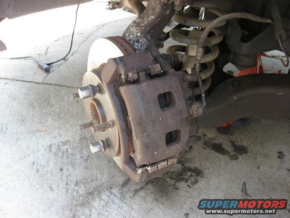 Brake caliper and rotor assembly on a concrete surface