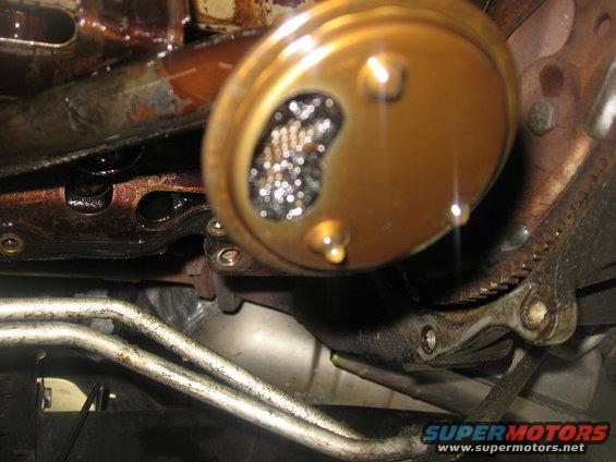 Close-up of a dirty oil pump screen with metal debris