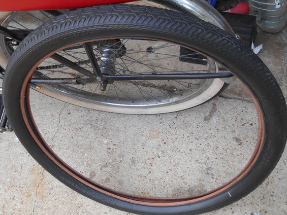 Bicycle wheel with black tire and copper rim, close-up