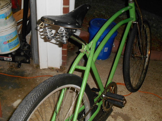 Green cruiser bicycle with black sprung seat and wide tires