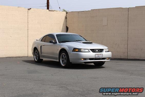 Silver 2002 Ford Mustang coupe with a hood scoop and a California license plate