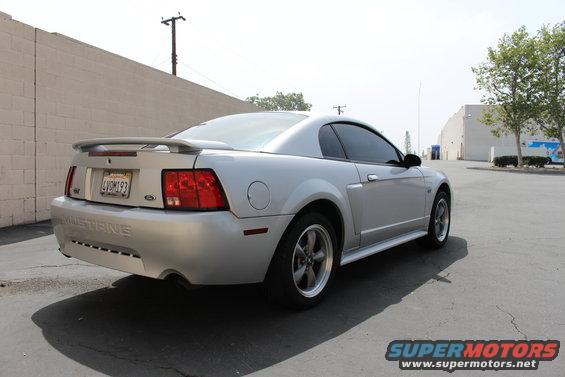 Silver 2002 Ford Mustang coupe with spoiler, rear 3/4 view