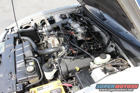 2002 Ford Mustang engine bay with V8 engine, air intake, battery, and coolant reservoir