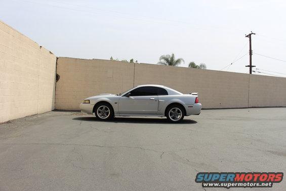 Silver 2002 Ford Mustang coupe parked on asphalt, side view