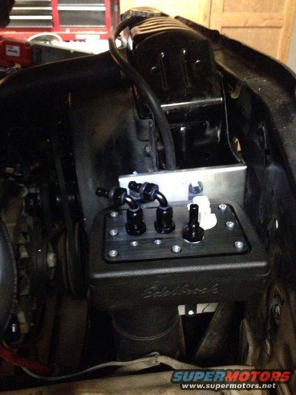 Engine bay with Edelbrock fuel pump assembly and black hoses