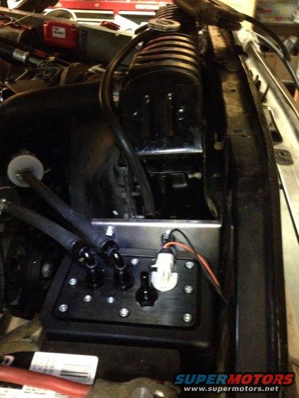 Engine bay showing a custom fuel pump assembly with braided lines and electrical connectors