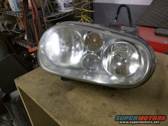 Headlight assembly with multiple bulbs on a wooden surface