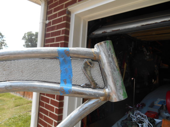 Cobra emblem on a metal frame, partially covered by blue tape