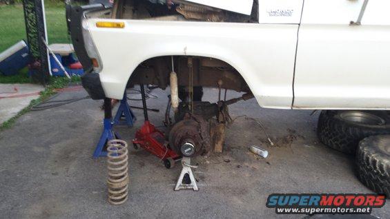 White 1979 Ford Bronco front suspension disassembled on jack stands