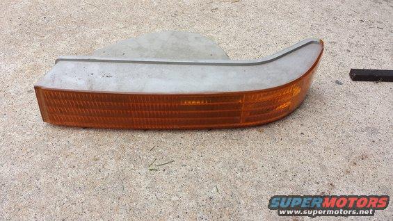 Orange Bronco turn signal assembly on concrete. Part is dusty and shows some wear