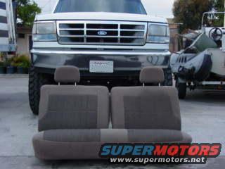 1992 Ford Bronco front grille and headlights with interior bench seat in foreground. Another vehicle is partially visible to the right
