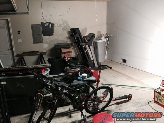Garage interior with two bicycles, a treadmill, and a water softener unit