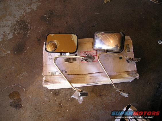 Two side mirrors, one chrome and one black, on a cardboard box