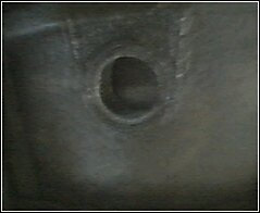 Close-up of a bolt hole on a dark metal part