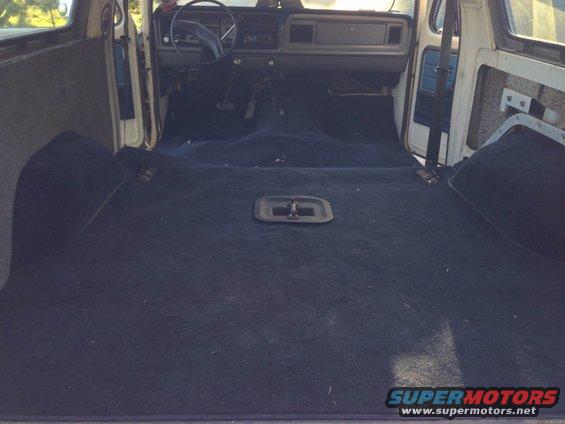 Interior view of a 1979 Ford Bronco, showing the dashboard and carpeted rear cargo area